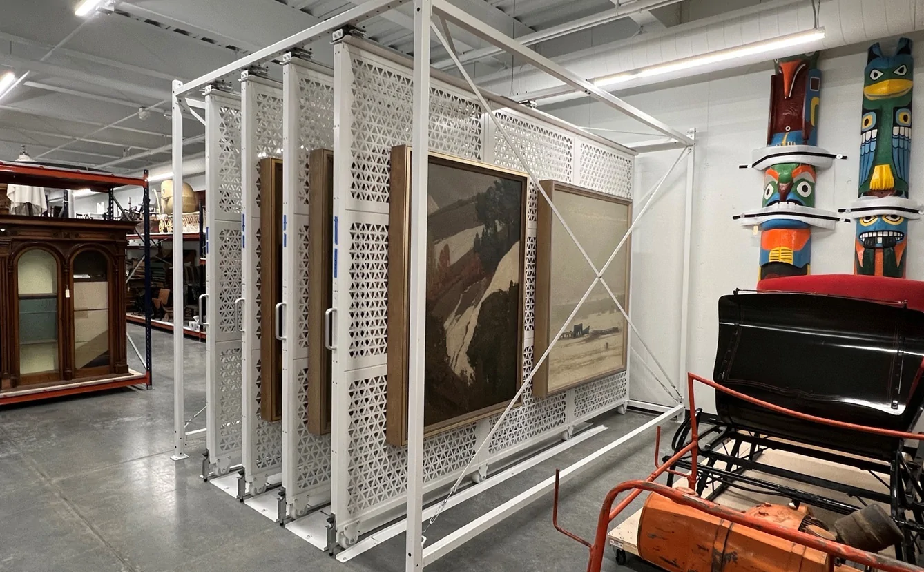 image of white sliding wire racks that are holding large canvas on each side.